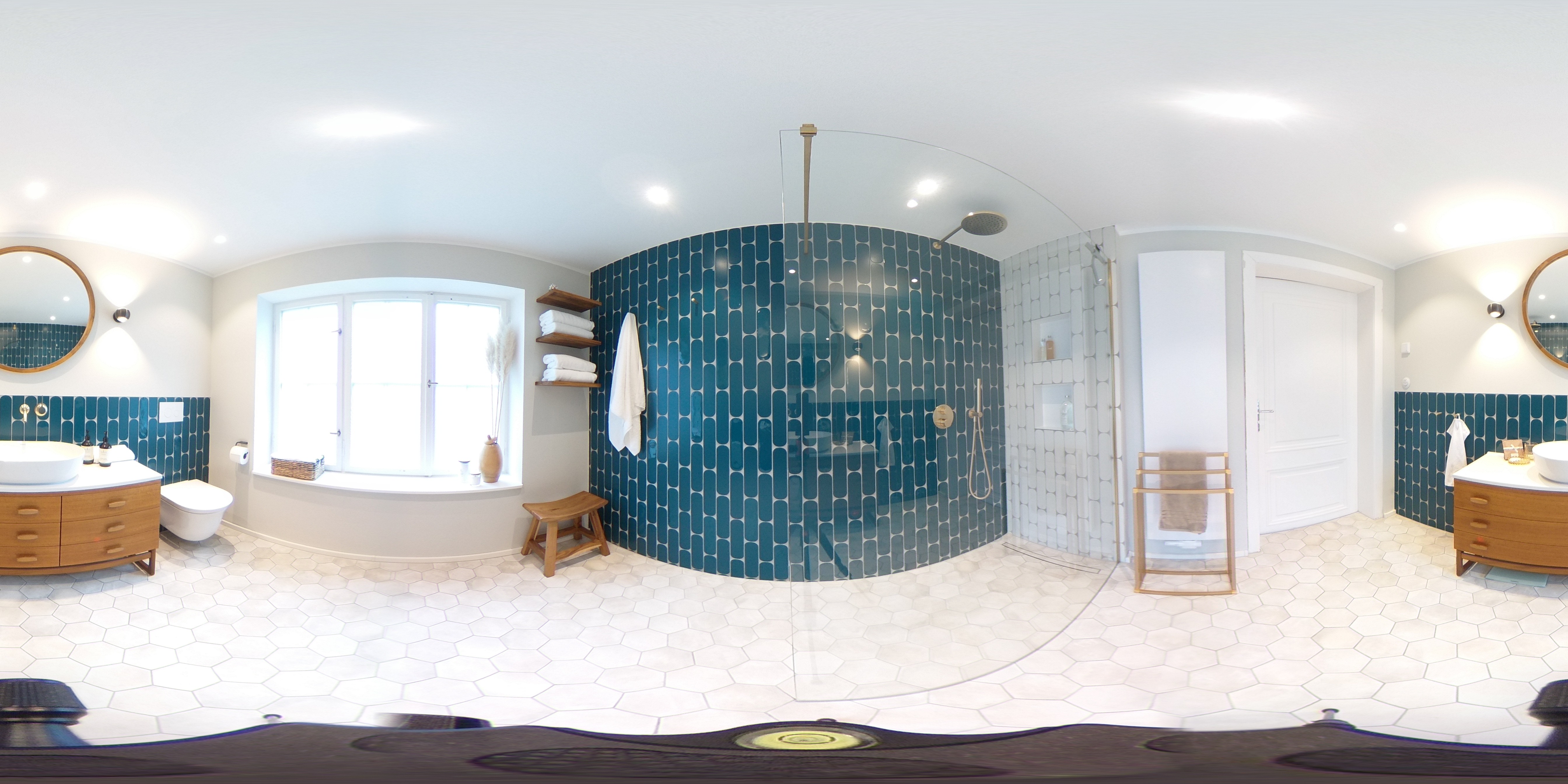 Ein großes Badezimmer mit türkisen Fliesen mit einem Holzwaschtisch und goldenen Armaturen, 360° Bild.