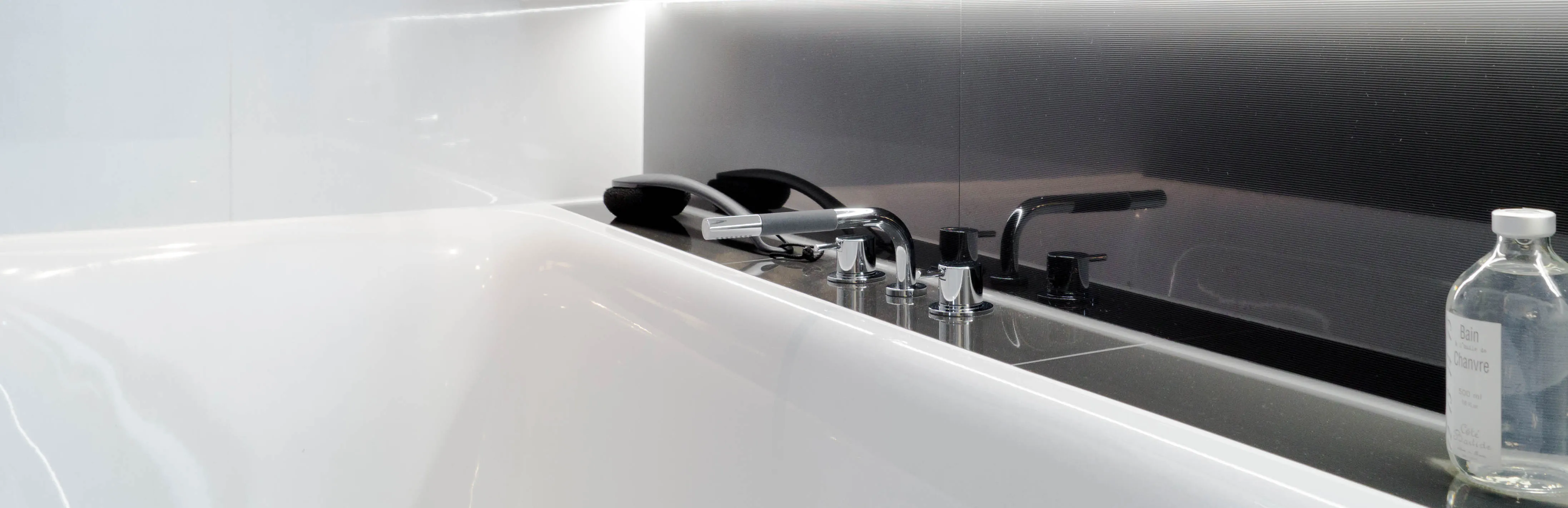 Schwarz-weiß gehaltene Badewanne mit silber glänzender Armatur in einem Klassikbad.