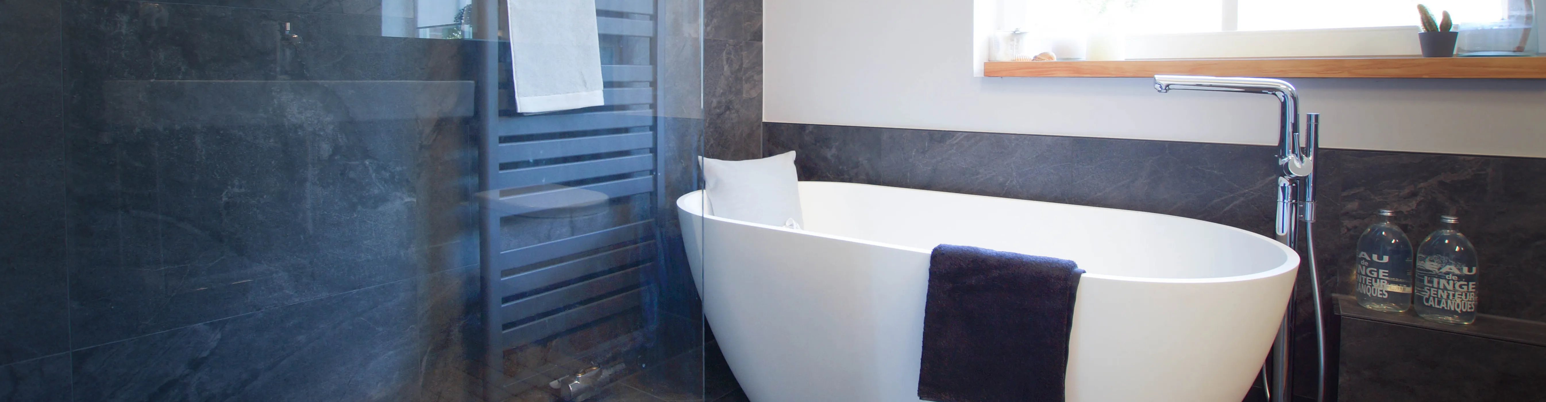 Header für ein modernes Bad mit freistehender Badewanne und Walk-In-Dusche vom Handwerksunternehmen bad & heizung Laabs in Potsdam.