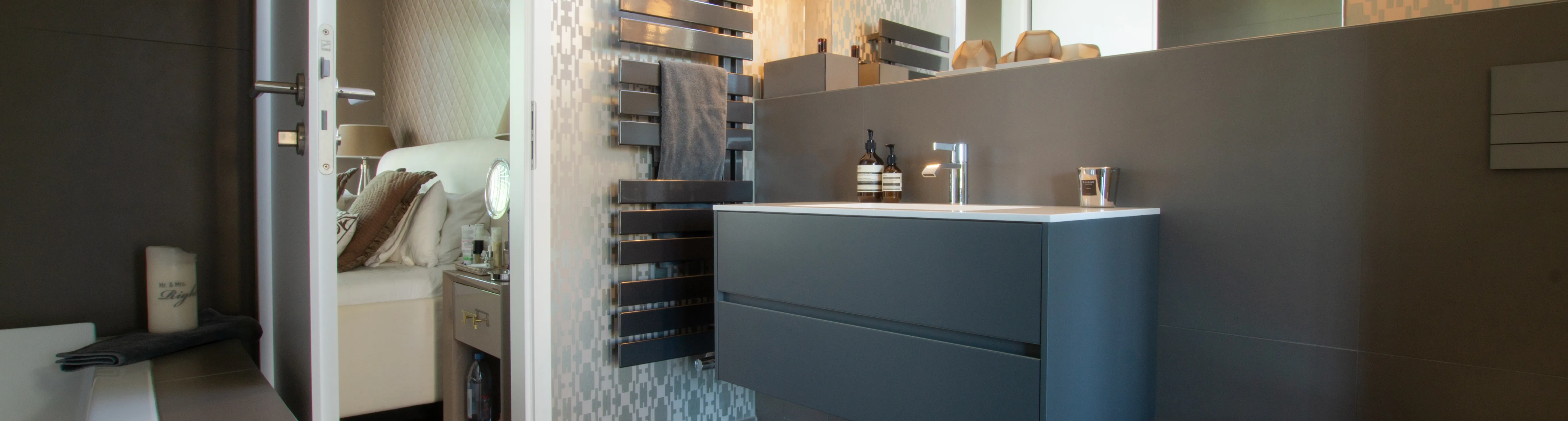 Modernes Komfortbad mit stilvollem Waschtisch, Design-Heizkörper und direktem Zugang zum Schlafzimmer.