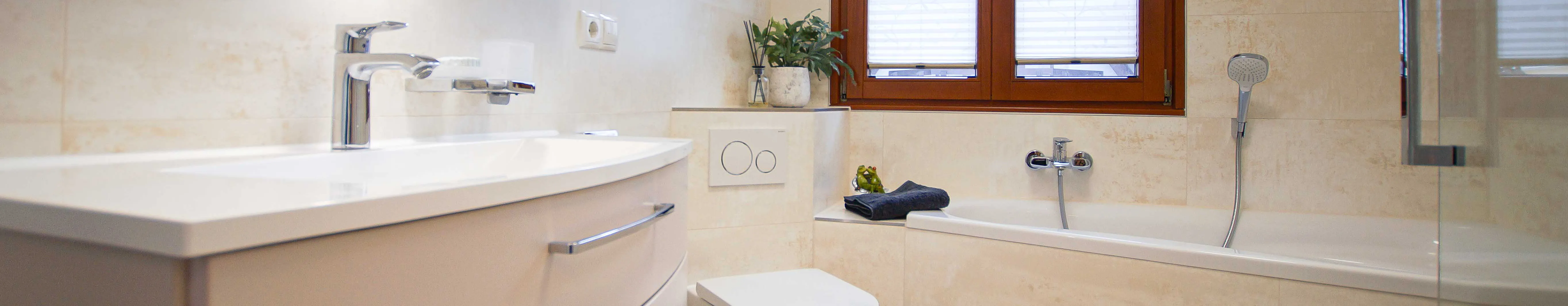 Komplettbad mit asymmetrischer Waschtisch von Creativbad, Eck-WC und raumsparender Badewanne.