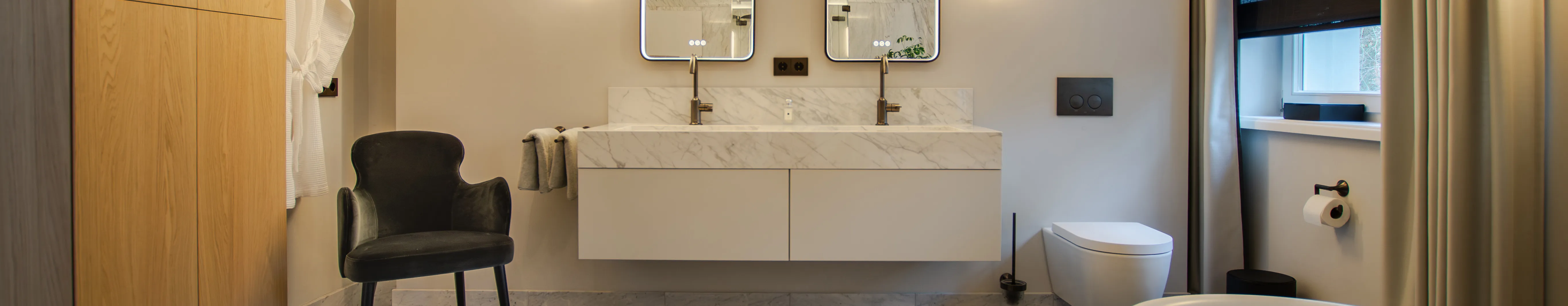 Doppelwaschtisch in Marmoroptik mit zwei Spiegeln, daneben sieht man ein wandhängendes WC von STARK.