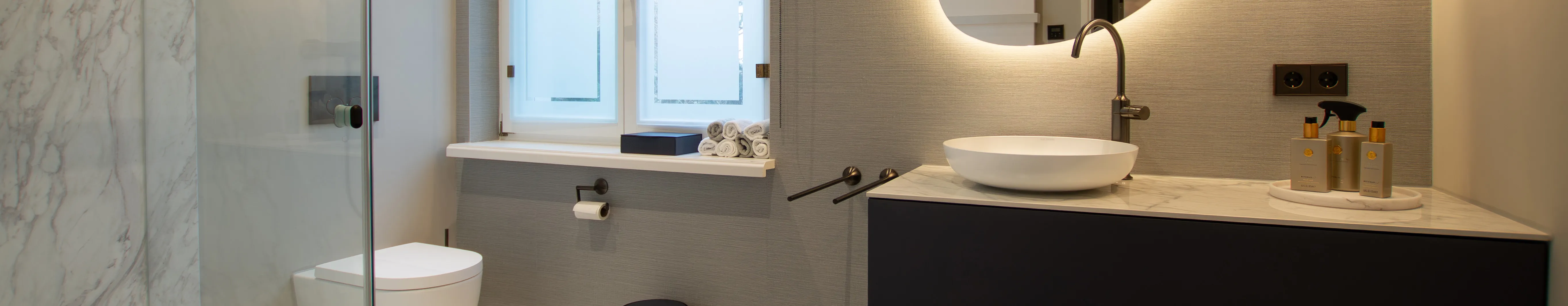 Modernes Gästebad mit Marmor-Dusche, hochwertigem Waschtisch und zeitlosem Design.