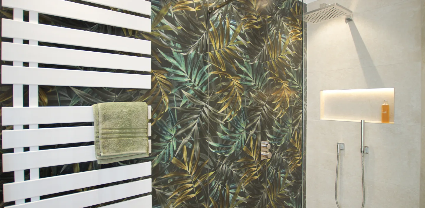 Gesamtübersicht eines Dschungelbads mit Palmendesign-Fliesen vom Handwerksunternehmen bad & heizung Laabs in Potsdam.