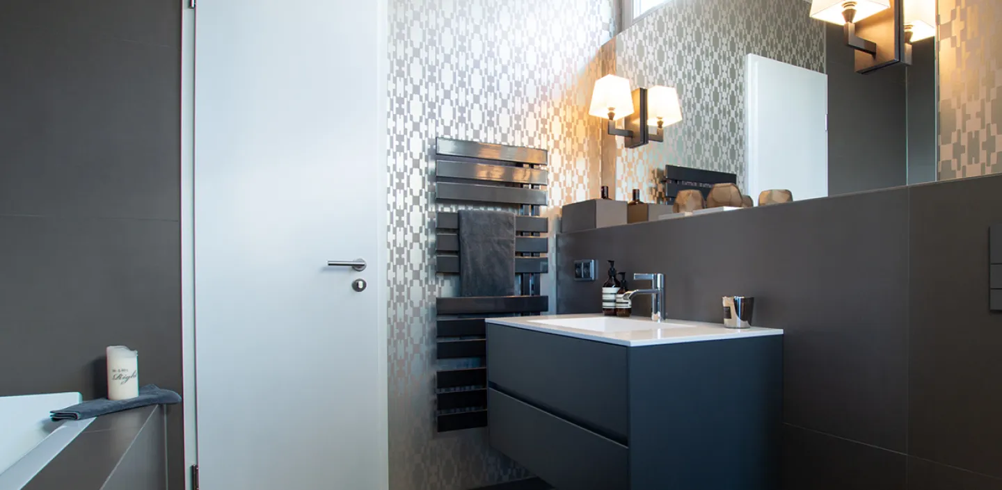Designer-Tapete und Waschtisch-Hängeschrank im Referenz-Durchgangsbad vom Handwerksunternehmen bad & heizung Laabs in Potsdam.