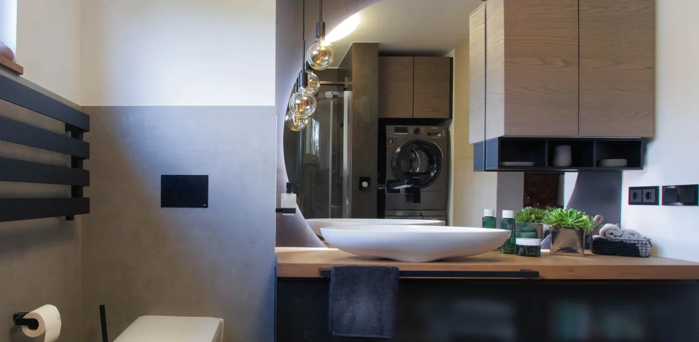 WC und Waschtisch mit großem, runden Spiegel in einem zeitlosen Bad vom Handwerksunternehmen bad & heizung Laabs in Potsdam.