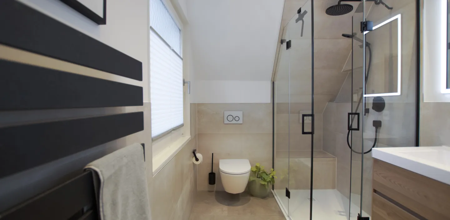 Elternbadezimmer mit Heizkörper im Vordergrund und im Hintergrund Wand-WC mit Walk In Dusche, Referenzbad von Laabs, Potsdam.