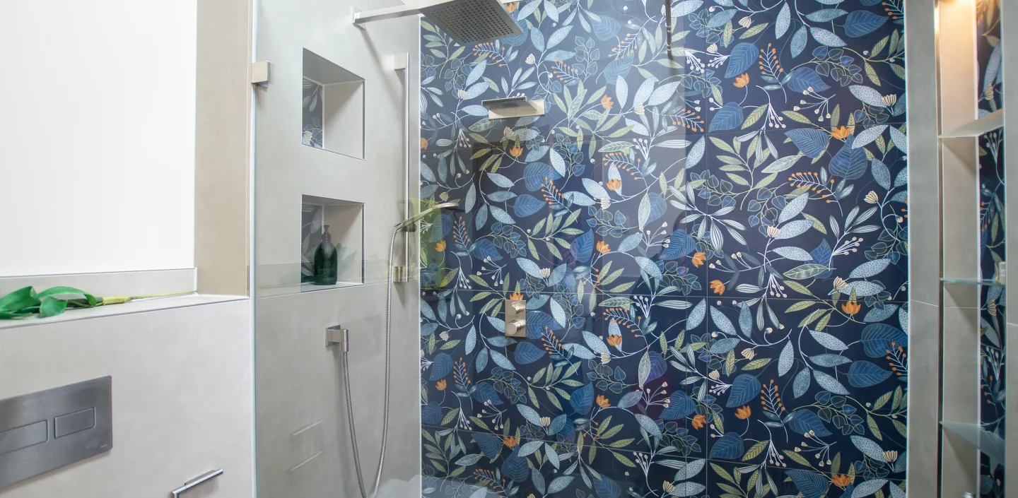 Großer Duschbereich mit Regen-Kopfbrause und Glas-Guschabtrennung, sowie florer Rückwand.