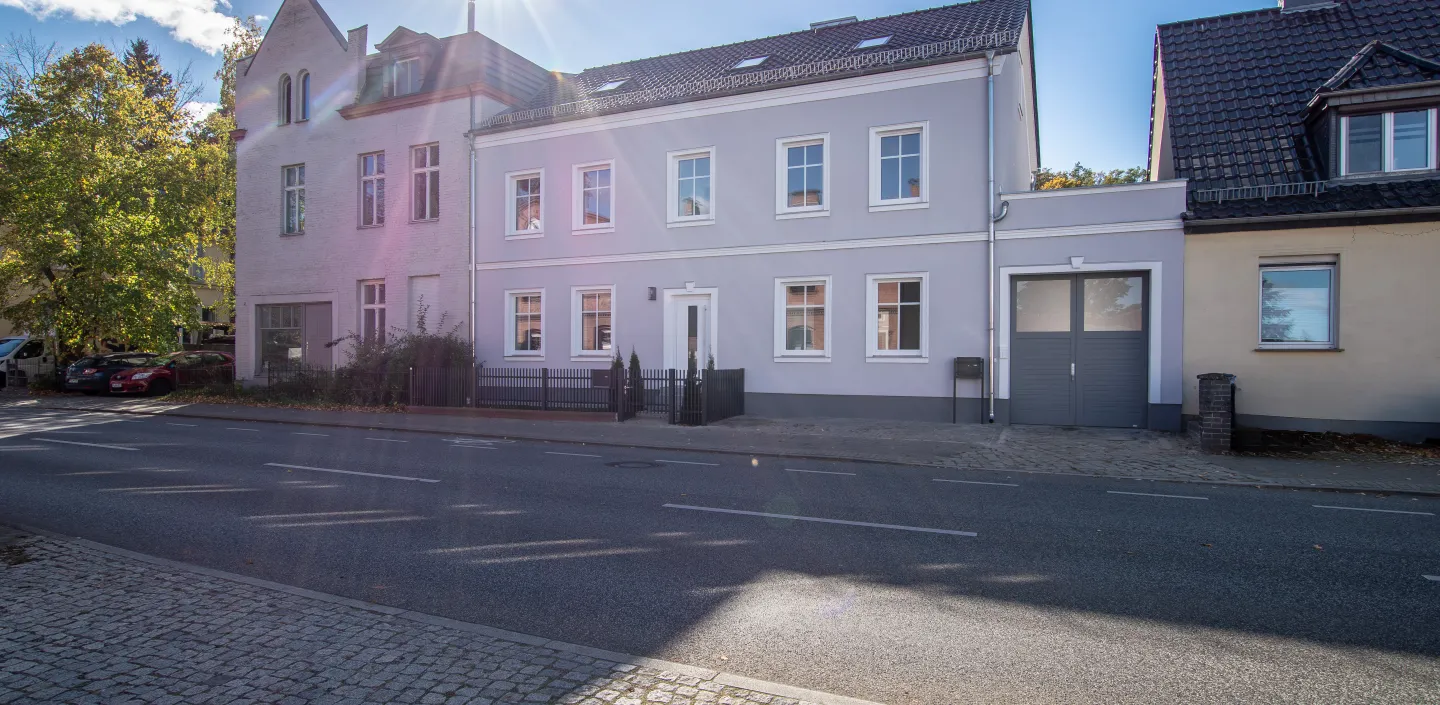 Außenansicht des Zweifamilienhauses in Potsdam Bornim mit sonnigen Himmel.