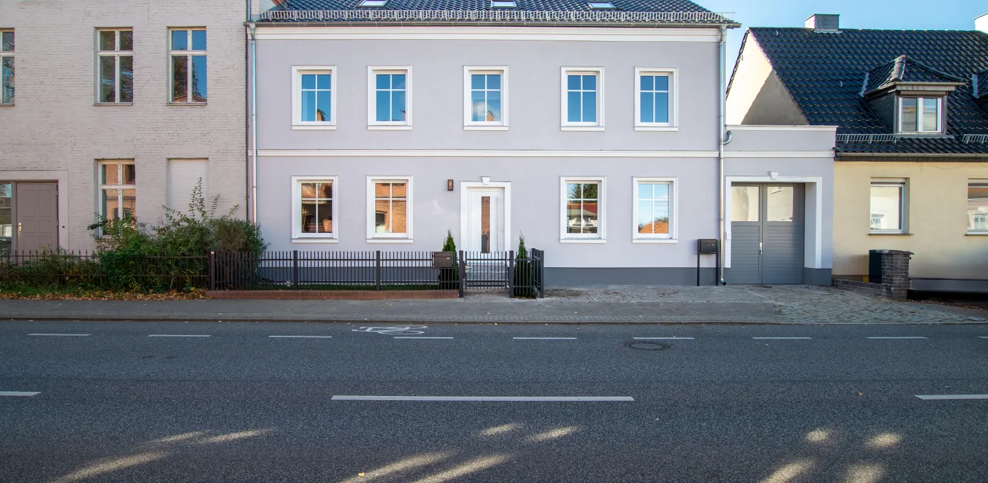 Stilvolles Zweifamilienhaus mit hellgrauer Fassade direkt an der Straße in Potsdam.
