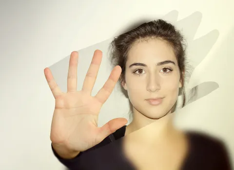 Frau wischt mit Hand über beschlagenen Badezimmer-Spiegel.