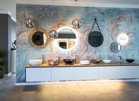 Verschiedene Waschtisch-Aufsatzschalen mit Spiegeln und Standarmaturen. 