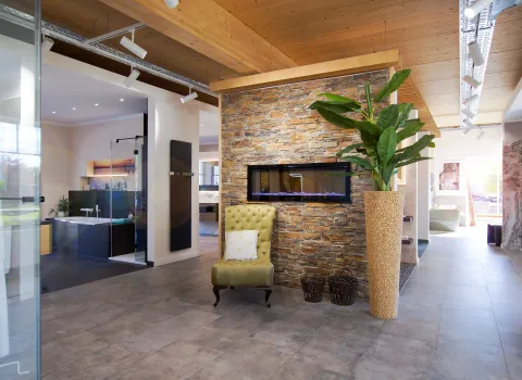 Eingangsbereich Ausstellung mit elektrischem Kamin von Wodtke und Sessel. 