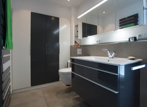 Komplettansicht des Duschbads in dunklen Farben vom Handwerksunternehmen bad & heizung Laabs in Potsdam.