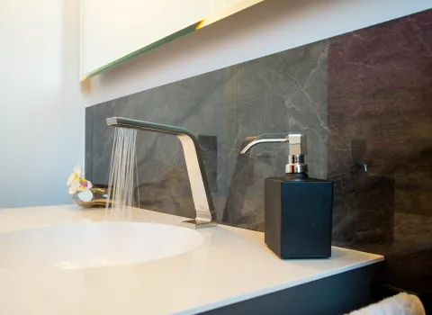 Waschbecken vor Marmorwand in einem Gästebad vom Handwerksunternehmen bad & Heizung Laabs in Potsdam.