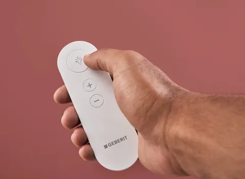 Fernbedienung für ein Dusch-WC von Geberit in einer Hand 