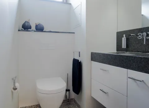 Gästebad von Laabs mit Naturstein, passend zum Klassikbad.