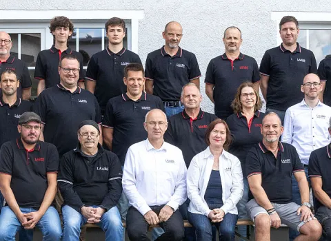 Das gesamte Team des SHK-Unternehmens LAABS posiert gemeinsam für ein Teamfoto vor dem Firmengebäude. 
