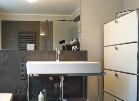 Offener Waschtisch und USM-Regal im modernen Bad vom Handwerksunternehmen bad & heizung Laabs in Potsdam.