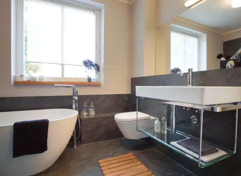 Offener Waschtisch und freistehende Badewanne im modernen Bad vom Handwerksunternehmen bad & heizung Laabs in Potsdam.