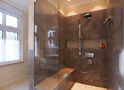 Walk-In-Regendusche mit beheizter Sitzbank im Premium-Duschbad vom Handwerksunternehmen bad & heizung Laabs in Potsdam.