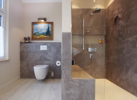 Gesamtübersicht eines Premium-Duschbads mit WC und Walk-In-Regendusche vom Handwerksunternehmen bad & heizung Laabs in Potsdam.