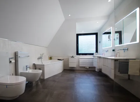 Gesamtübersicht eines Komplettbads mit Dusch-WC und Schminkspiegel vom Handwerksunternehmen bad & heizung Laabs in Potsdam.