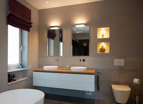 Beleuchtungskonzept im grau gehaltenen Komplettbad vom Handwerksunternehmen bad & heizung Laabs in Potsdam.