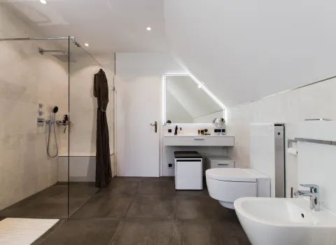 Walk-in-Dusche und Schminktisch mit Kosmetikspiegel im Komplettbad vom Handwerksunternehmen bad & heizung Laabs in Potsdam.