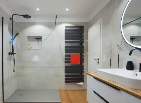 Walk-In-Regendusche und Design-Heizkörper in schwarz im Familienbad vom Handwerksunternehmen bad & heizung Laabs in Potsdam.
