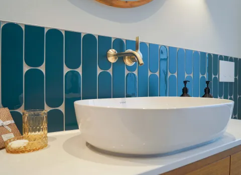 Aufsatzschale für einen Waschtisch aus Echtholz im farbigen Bad mit blauen Fliesen vom Handwerksunternehmen bad & heizung Laabs in Potsdam.