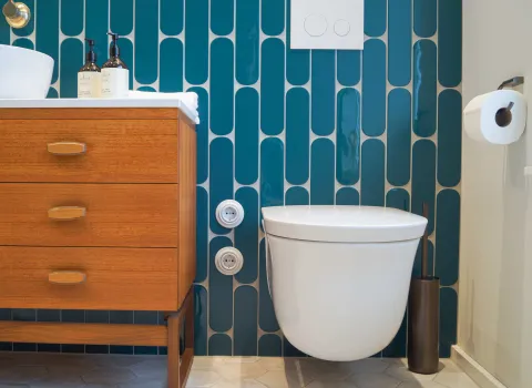 WC vor blauen Fliesen im farbigen Bad vom Handwerksunternehmen bad & heizung Laabs in Potsdam.
