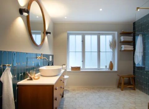 Gesamtübersicht eines farbigen Bads mit individuellem Waschtisch vom Handwerksunternehmen bad & heizung Laabs in Potsdam.