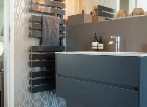 Modernes Komfortbad mit stilvollem Waschtisch, Design-Heizkörper und direktem Zugang zum Schlafzimmer.