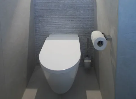 WC mit WC-Rollen Halter und WC-Bürste. 