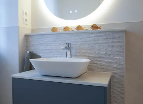 Aufsatzwaschtisch mit Armatur in chrom mit beleuchteten Spiegel.