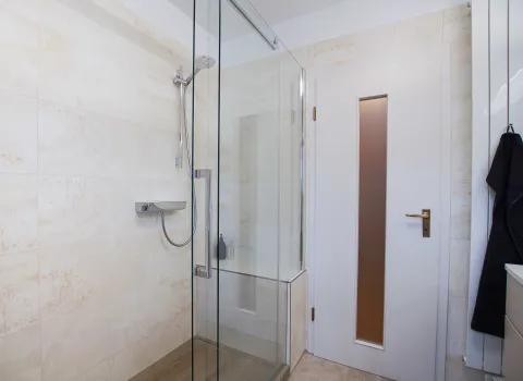 Leicht begehbare Dusche in einem Komplettbad mit einer Schiebtür von HSK mit einer Twin Seal Beschichtung.