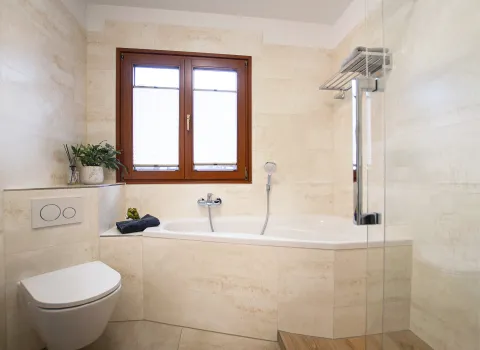 Raumsparende Wanne von repabad - weiß, eingefliest mit Handtuchablage. 