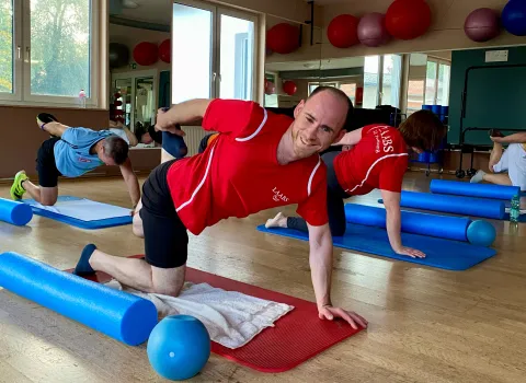 Mitarbeiter macht Sportübungen beim Firmensport.
