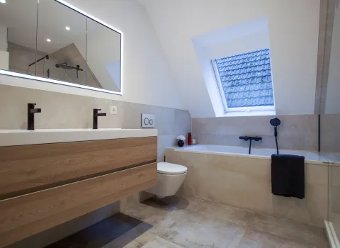 Großzügiges Badezimmer mit Dachschräge und Badewanne, Wand-WC und LED Lichtspiegel, Referenzbad von Laabs, Potsdam.