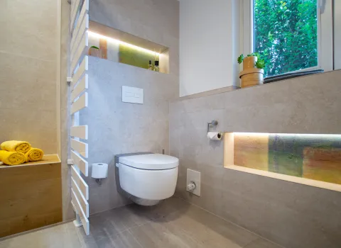 Dusch WC mit beleuchteten Nischen und Regler für Fußbodenheizung.