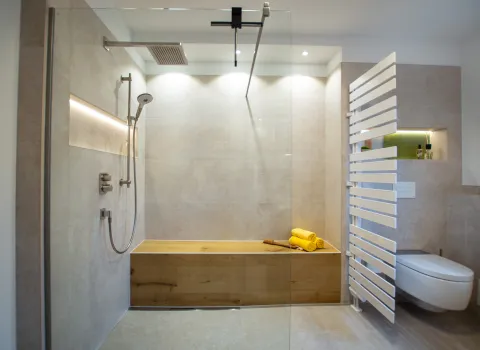 Geräumige Walk IN Dusche mit Glas-Duschabtrennung und langer Sitzbank.