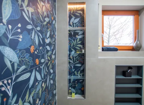 Duschbereich mit in die Wand eingebautem Regal und Glasablageflächen.