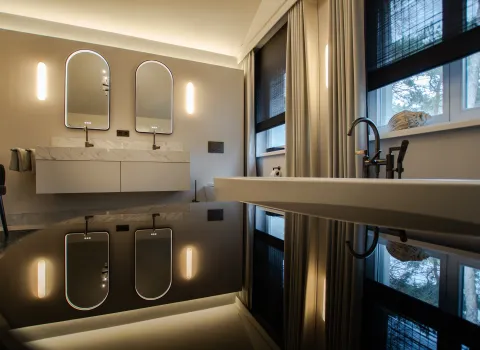 Luxusbadezimmer in dunklen Farben mit Doppelwaschtisch und stilvollen Elementen.