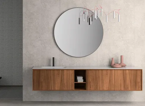 Langer, freischwebender Waschtisch aus dunklem Holz mit rundem Spiegel und minimalistischer Armatur in modernem Badezimmer von Stocco.