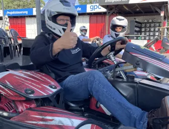Mann sitzt im Gokart und hebt den Daumen.