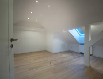 Leerer Raum im Dachgeschoss mit Dachflächenfenster.