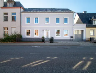 Stilvolles Zweifamilienhaus mit hellgrauer Fassade direkt an der Straße in Potsdam.