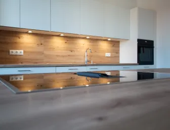 Küchenzeile mit Arbeitsplatte und Ceranfeld mit integriertem Abzug.