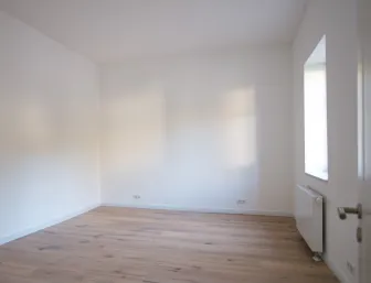Leerer Raum, möglich nutzbar als Schlafzimmer mit zwei Fenstern und Eichenparkett.